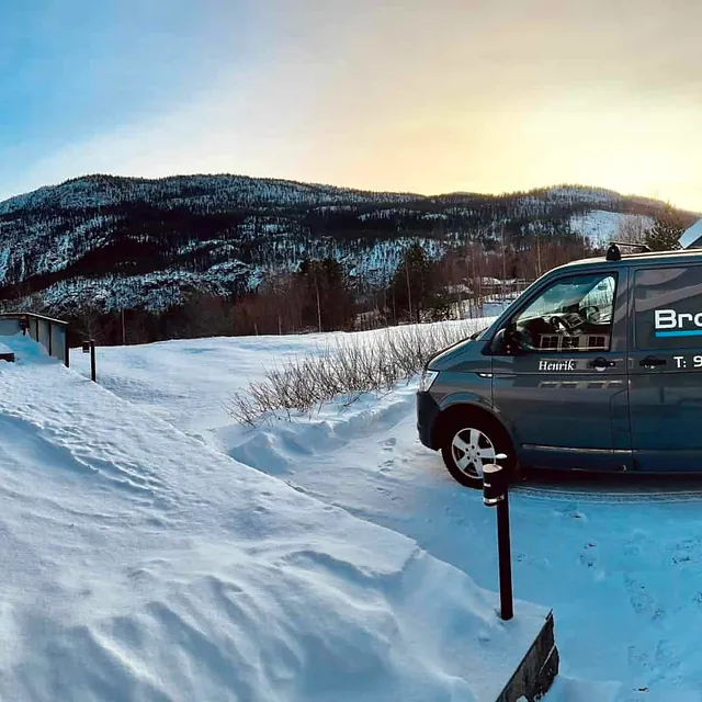 Rørleggerbil fra Brokke VVS AS parkert i vinterlandskap med fjellutsikt.